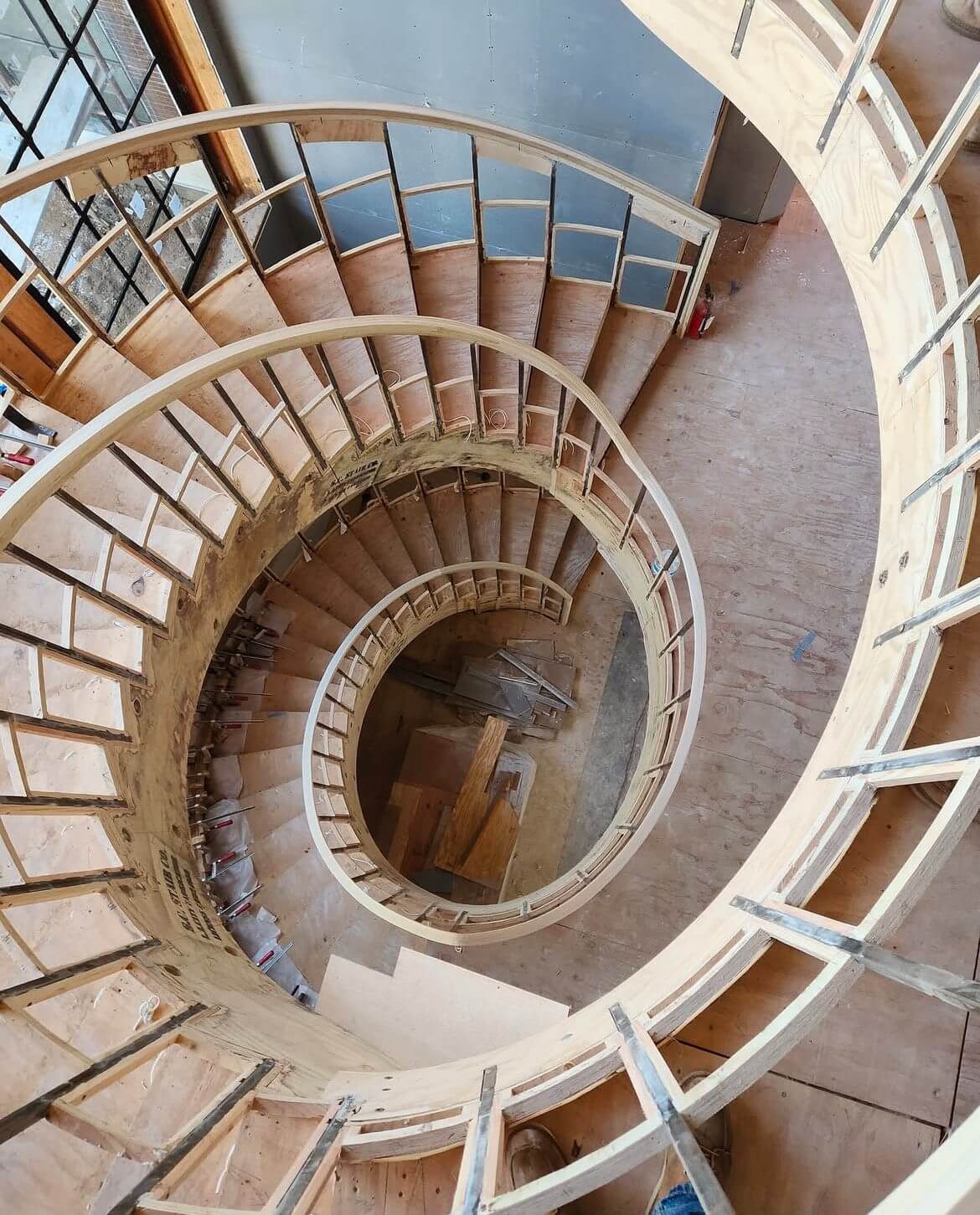 A spiral staircase with wooden steps and handrails.