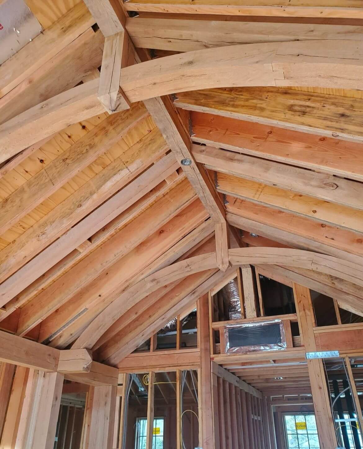 A wooden ceiling with windows and beams in it.